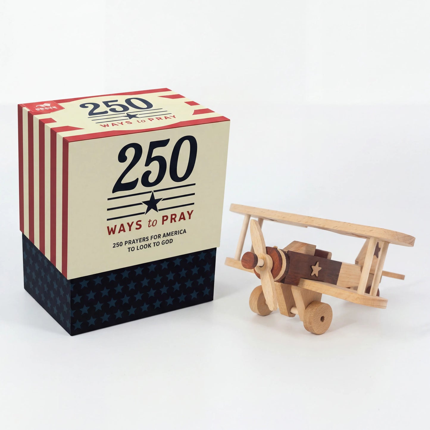 Book titled '250 Ways to Pray' with a wooden airplane model on a white background