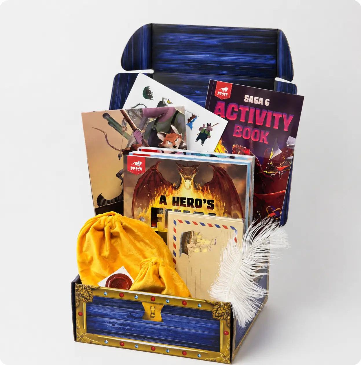A treasure chest themed educational activity kit from The Story Club, featuring a blue and gold wooden chest, a yellow drawstring pouch, a white feather, a 'Saga 6 Activity Book', and various illustrated cards and inserts, all arranged on a clean white background.