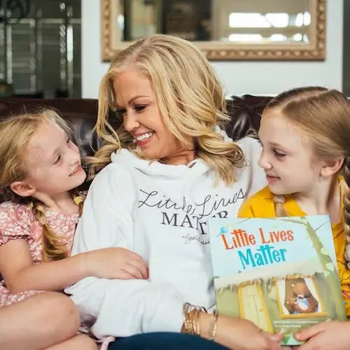 A mom and her daughters laughing and talking about Little Lives Matter,  a BRAVE Books book