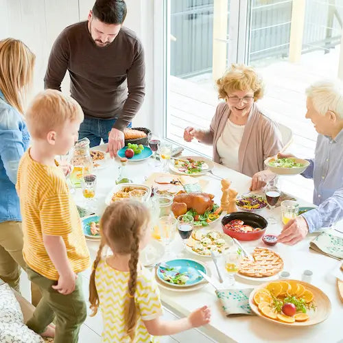 An entire family sitting down at the table and enjoying dinner