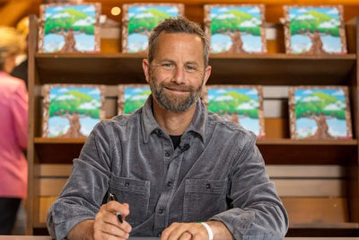 Kirk Cameron smiling while he signs his children's book, As You Grow