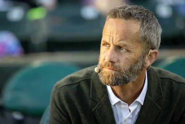 Man with a beard and microphone outdoors, possibly at an event.