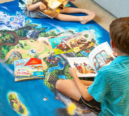 LIttle kids reading BRAVE books on a freedom Island Playmat