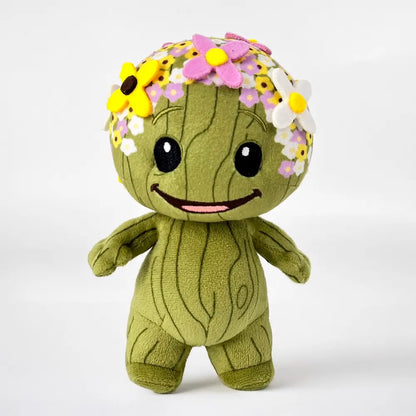 Plush toy resembling a character with floral headband on a white background
