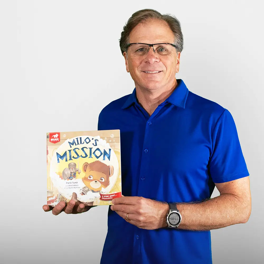 Man holding a book titled 'Milo's Mission' against a plain background