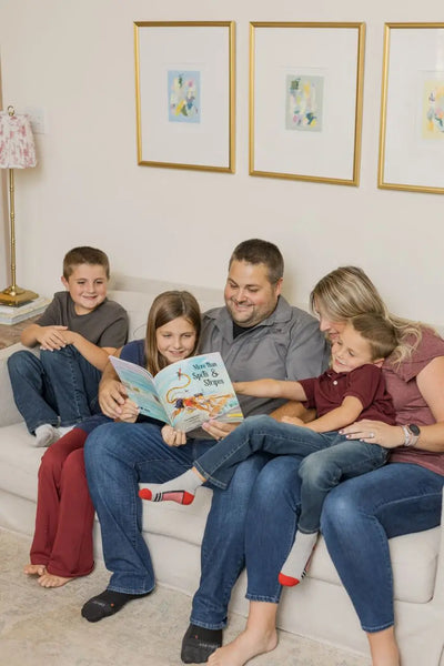 A family with the 2 parents reading a BRAVE Books book